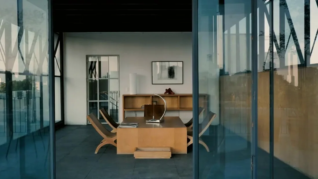 Interior contemporâneo com móveis de madeira e grandes painéis de vidro